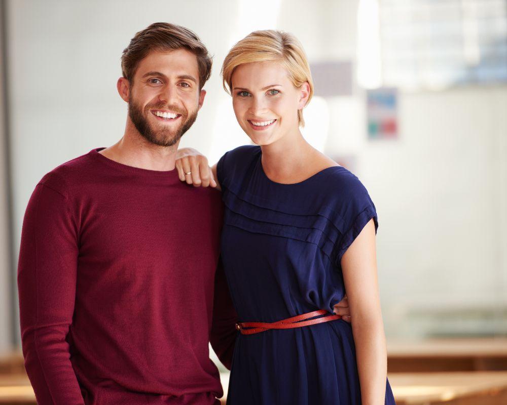 A man and woman standing together smiling