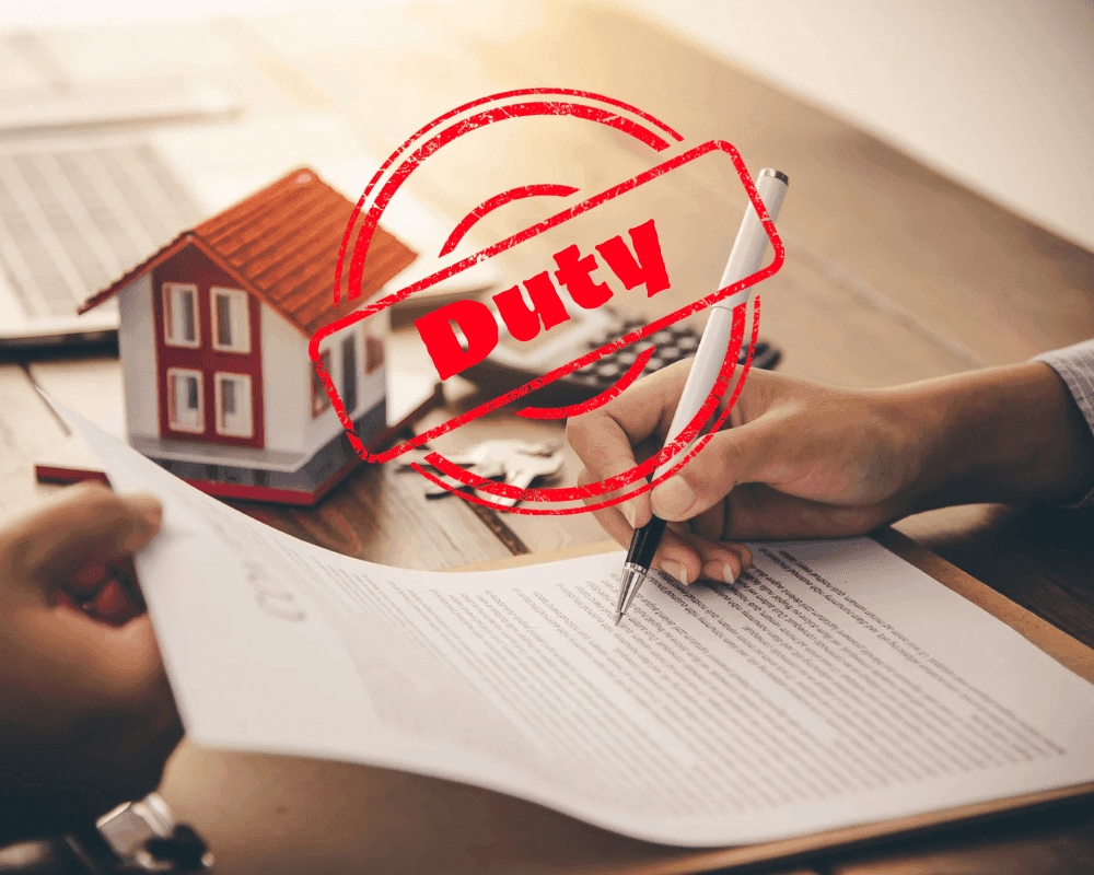 Hand signing a home loan contract with a bug red stamp reading 'Duty'