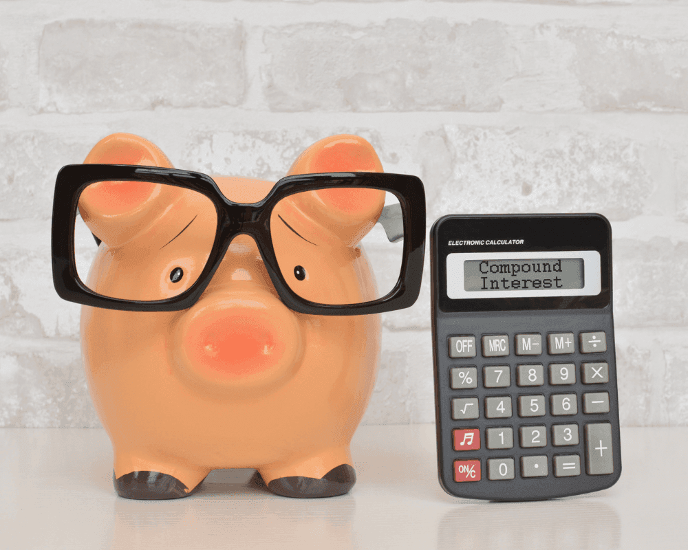 Image of a piggy bank wearing glasses next to a calculator to calculate savings